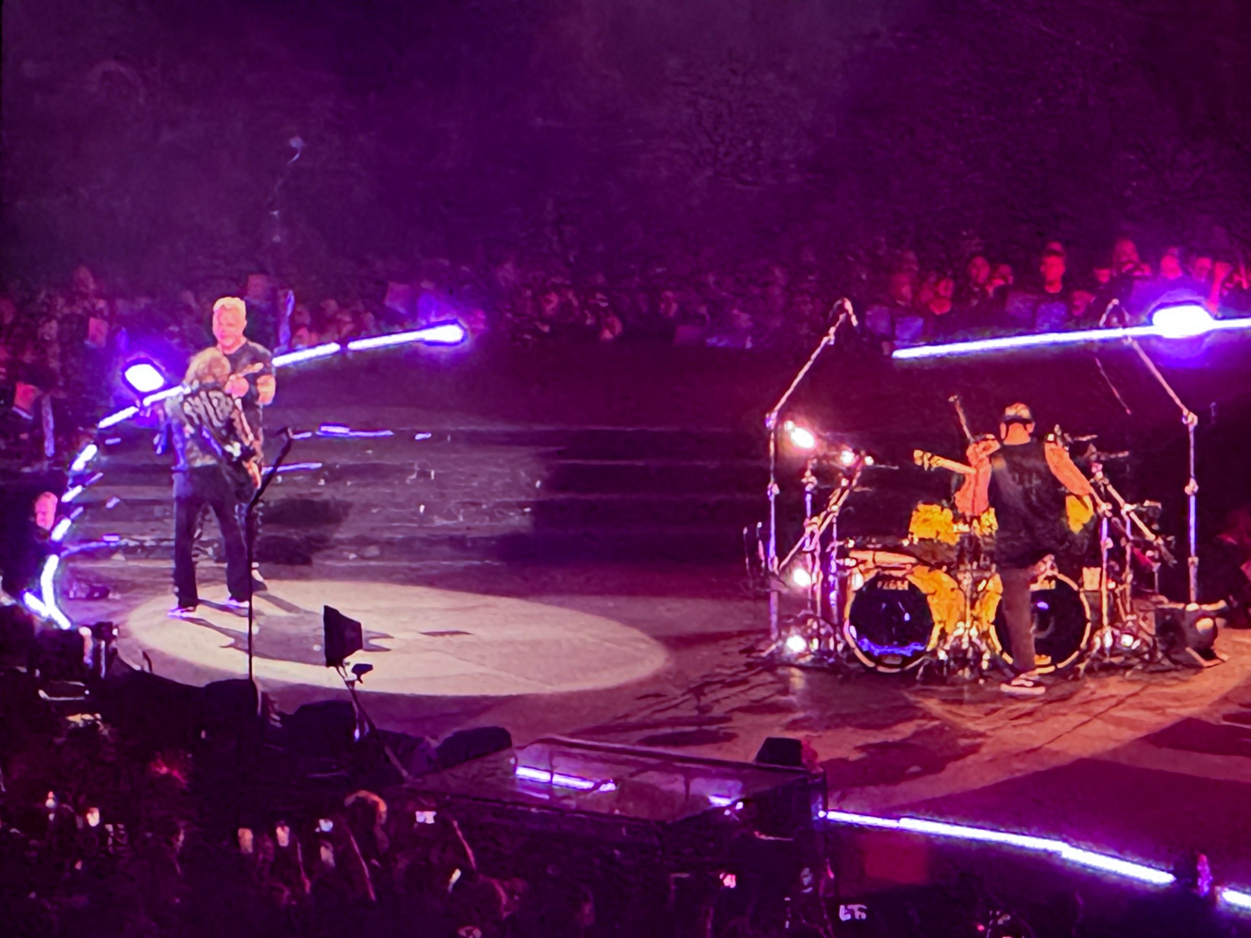 James and Kirk aggressively play guitar at each other while Lars thumps along with them.